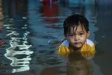 Người dân đắp ‘đê’ trước cửa nhà, trẻ em bơi giữa dòng triều cường đạt đỉnh tại TP.HCM