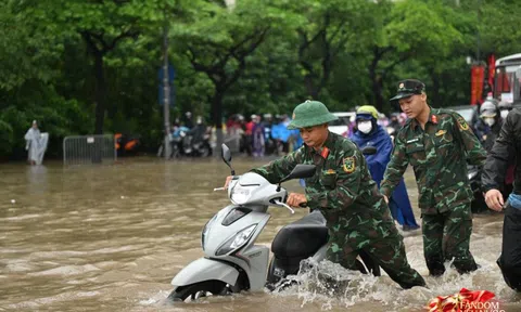 Ảnh đẹp sáng nay: Các chiến sĩ làm nhiệm vụ A80 lội nước đẩy xe, dìu dân qua đoạn ngập sâu ở Hà Nội