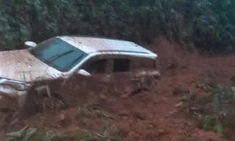 Ô tô 7 chỗ màu trắng bị đất, đá vùi lấp