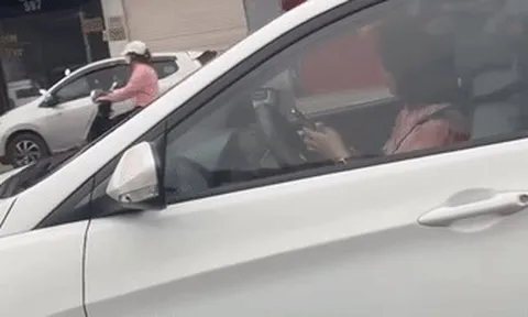 Lái ô tô vẫn dùng hai tay bấm điện thoại, nữ tài xế bị ghi hình gửi CSGT xử phạt