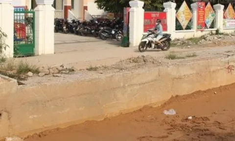 Quốc lộ 14B đào xới dang dở, dân vượt “hào sâu” mới vào được cổng ủy ban