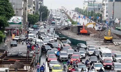 Người Hà Nội đội mưa lớn đi làm, ‘chôn chân’ trên những tuyến đường ùn tắc