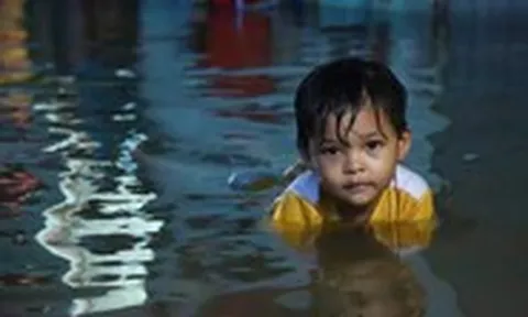 Người dân đắp ‘đê’ trước cửa nhà, trẻ em bơi giữa dòng triều cường đạt đỉnh tại TP.HCM