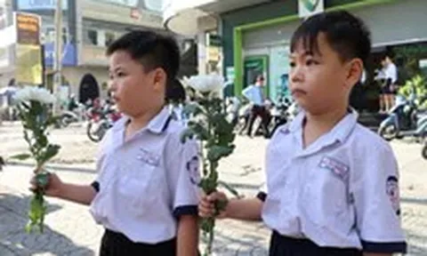 Người dân cầm hoa trắng đợi tiễn đưa các anh