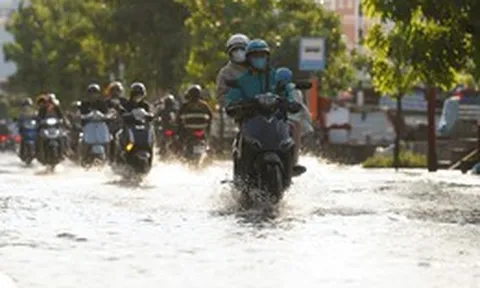Triều cường dâng cao giữa trời nắng nóng, người dân TP.HCM bì bõm lội nước đi về