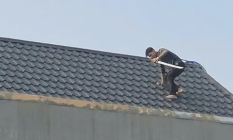 Cảnh sát vây bắt hai người cầm hung khí cố thủ trên mái nhà ở Thanh Hóa