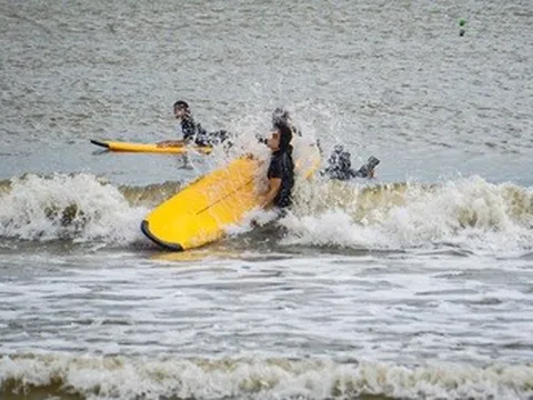 Du khách ra biển lướt sóng trước giờ bão Kalmaegi áp sát
